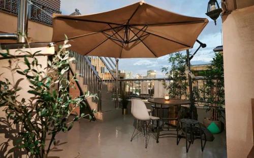 taras ze stołem, krzesłami i parasolem w obiekcie Bliss penthouse2 w Seulu