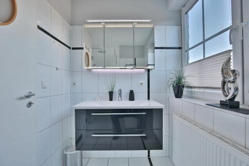 bagno bianco con lavandino e specchio di Bädervilla Bergstraße 30 Bädervilla Bergstraße Appartement 9 a Timmendorfer Strand
