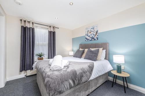 a bedroom with a large bed with blue walls at Liquorice Lodging in Lincoln