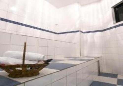 uma casa de banho com um cesto de toalhas num balcão em Hotel Minas Tower em Leopoldina