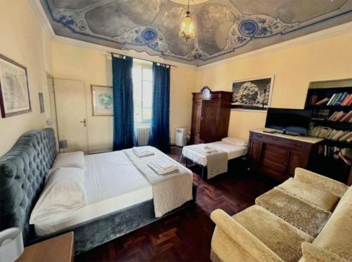 1 dormitorio con cama, escritorio y sofá en Bresbot B&B, en Bressana Bottarone