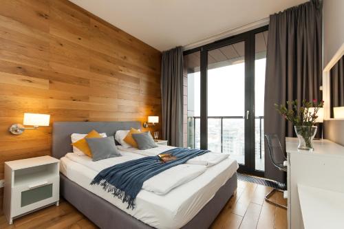 Un dormitorio con una cama grande con una pared de madera. en Dream Team Nordic Haven, en Bydgoszcz