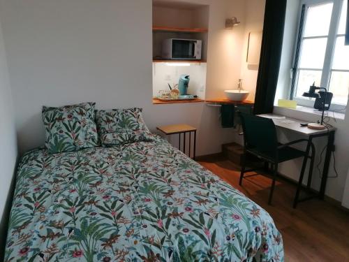 une chambre avec un lit et un bureau avec un ordinateur dans l'établissement Mini Garni Vendémiaire, à Vesoul