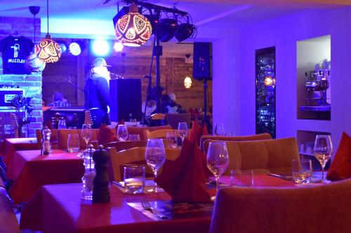 Black Forest Hotel Kappel-Grafenhausen في كابل غرافنهاوسن: مطعم بطاولات وكراسي مع كؤوس للنبيذ