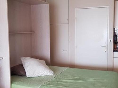 - une chambre avec un lit doté d'un oreiller et d'un placard dans l'établissement Studio cabine climatisé avec terrasse, parking, animaux admis - FR-1-100-184, à Cavalaire-sur-Mer