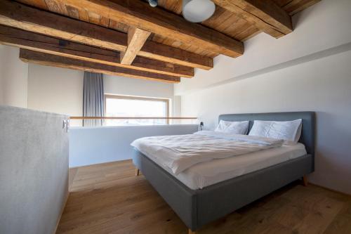 um quarto com uma cama e um tecto em madeira em Ferien im Kornhaus am Bodensee 1 em Romanshorn