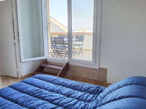 Cette chambre dispose de 2 lits bleus et d'un balcon. dans l'établissement Appartement 2 pièces avec mezzanine et toit terrasse, Marseillan-Plage, 6 couchages - FR-1-326-720, à Marseillan