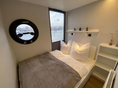 a small bedroom with a bed with a window at Hausboot Fjord Vineta mit Biosauna in Barth in Barth
