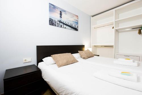1 dormitorio con 1 cama blanca grande y 2 almohadas en Bakea by Smiling Rentals, en Hondarribia