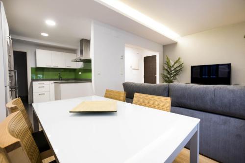 a kitchen and living room with a table and a couch at Bakea by Smiling Rentals in Hondarribia