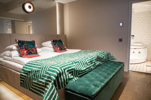 a bedroom with a bed with a green and white blanket at Original Sokos Hotel Vaakuna Seinäjoki in Seinäjoki