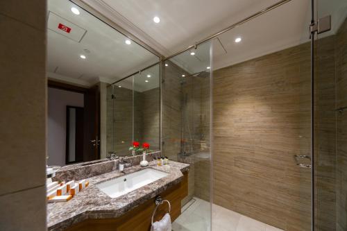 a bathroom with a sink and a shower at Retaj Baywalk Residence in Doha