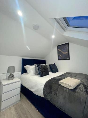 1 dormitorio con 2 camas, mesita de noche y ventana en Huntingdon Luxury Apartments en Huntingdon