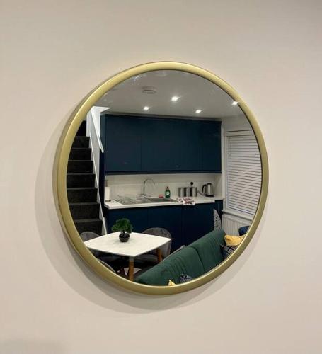 a mirror reflecting a living room with a table and a kitchen at Huntingdon Luxury Apartments in Huntingdon