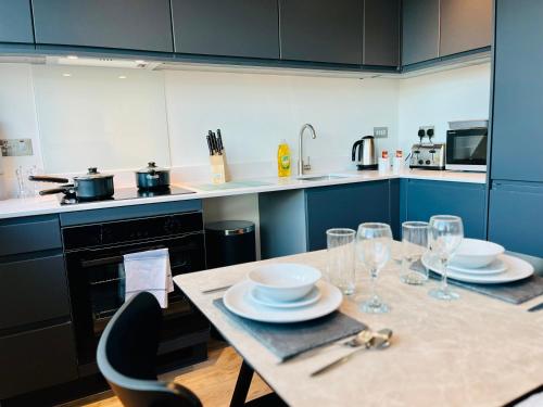 uma cozinha com uma mesa com pratos e copos de vinho em Spectacular Studio Apartment near to Old Trafford stadium em Manchester