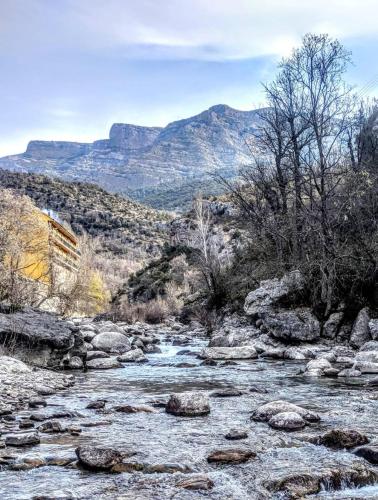 a river with rocks and mountains in the background at Hotel Casa Peix in Serraduy