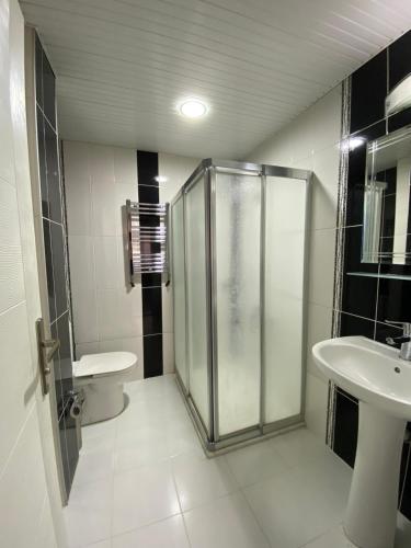a bathroom with a shower and a toilet and a sink at OTEL KING in Isparta