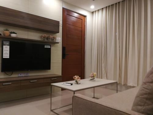sala de estar con TV, sofá y mesa en Adria Residences - Sapphire Garden - 2 Bedroom for 4 person, en Manila