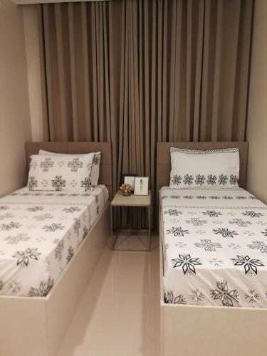 two beds sitting next to each other in a room at Adria Residences - Sapphire Garden - 2 Bedroom for 4 person in Manila
