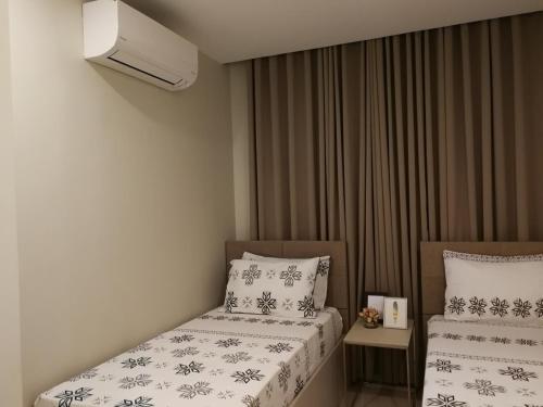 a small bedroom with two beds and a heater at Adria Residences - Sapphire Garden - 2 Bedroom for 4 person in Manila
