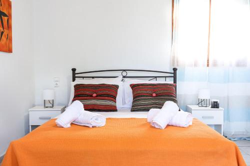 a bedroom with an orange bed with two towels on it at Creta 2 bedrooms 6 persons village house in Vasilópoulon
