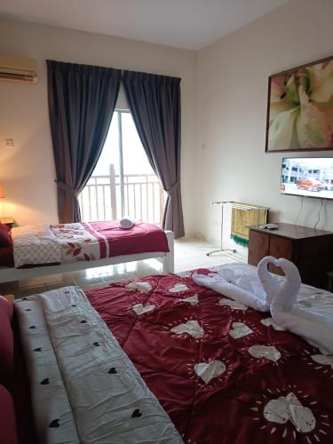 a hotel room with two beds with swans on it at Sofea Inn Bukit Merah - Suria A7733 in Kampong Selemat