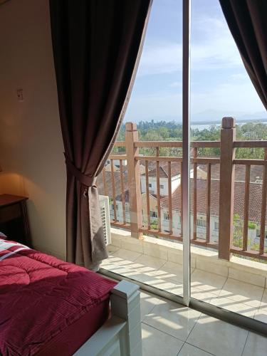 a bedroom with a large window and a balcony at Sofea Inn Bukit Merah - Suria A7733 in Kampong Selemat