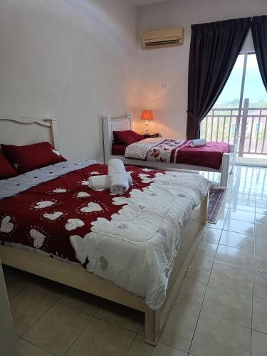 two beds in a room with a window at Sofea Inn Bukit Merah - Suria A7733 in Kampong Selemat