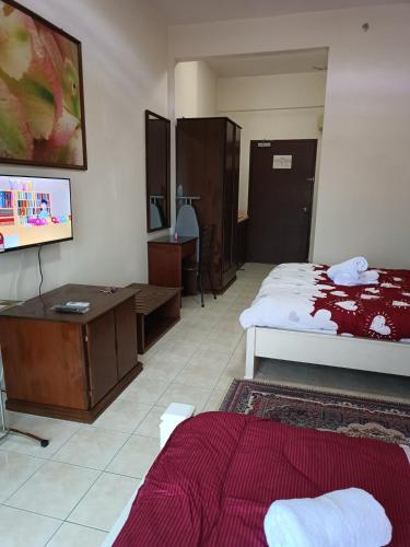 a hotel room with two beds and a desk and a bed at Sofea Inn Bukit Merah - Suria A7733 in Kampong Selemat