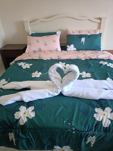 two swans are forming a heart on a bed at Sofea Inn Bukit Merah - Suria A7733 in Kampong Selemat