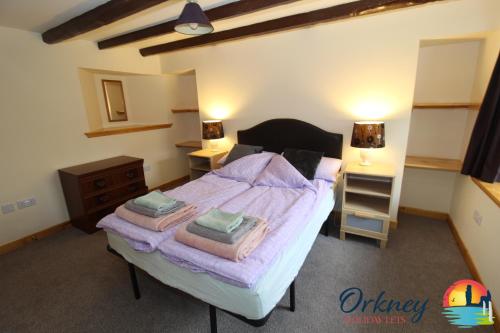 um quarto com uma cama com duas toalhas em 89 Victoria Street, Kirkwall, Orkney - OR00066F em Orkney