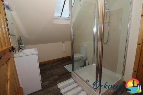 uma casa de banho com um chuveiro e um WC. em 89 Victoria Street, Kirkwall, Orkney - OR00066F em Orkney