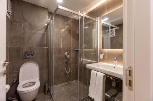a bathroom with a shower and a toilet and a sink at Lilium Luxury Suites in Istanbul