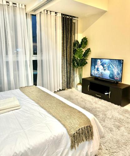 1 dormitorio con 1 cama y TV de pantalla plana en Lovely 1bedroom in Parksuites, en Manila
