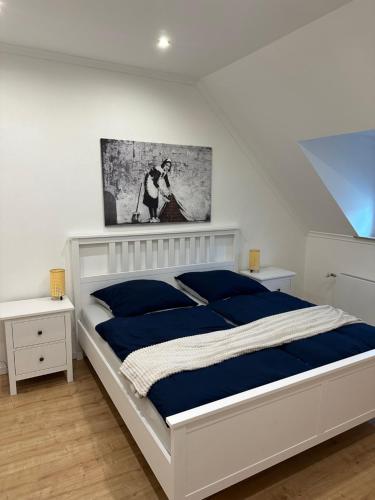 1 dormitorio con 1 cama blanca grande con sábanas azules en Stadthaus Apartment Bachperle, en Mayen