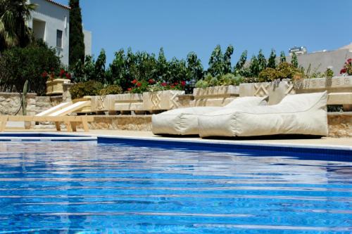 a swimming pool with a mattress next to a swimming pool at Luxury Villa Noesis with Pool and Seaview in Roussospítion