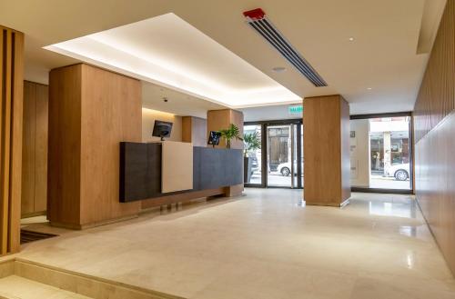 an office lobby with a television and wooden walls at Cyan Hotel de Las Americas in Buenos Aires