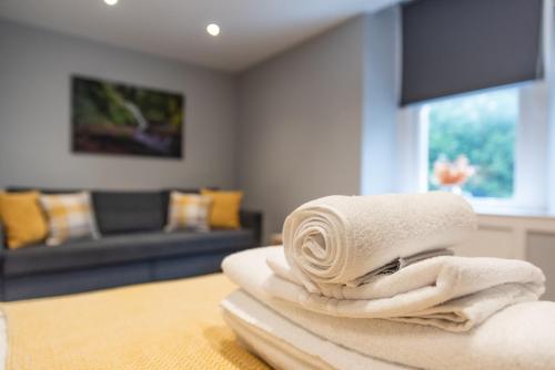 a pile of towels sitting on a table in a living room at Union Street Suites in Kelso