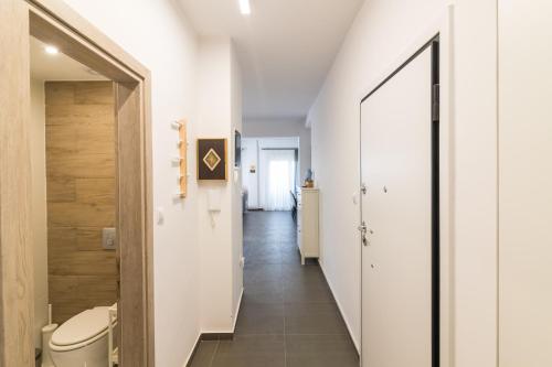 a bathroom with a toilet and a hallway at F & B Collection - 3 Bedroom Penthouse in Thessaloniki