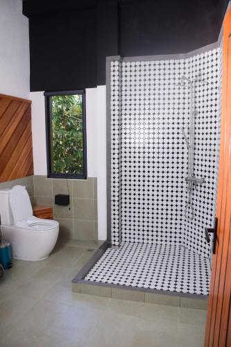 a bathroom with a shower and a toilet at Mango Tree Villa Bentota in Bentota