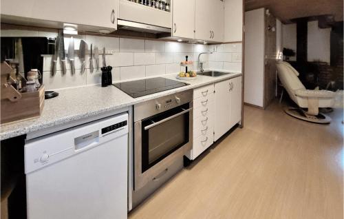 a kitchen with white cabinets and a stove top oven at 3 Bedroom Lovely Home In Åsljunga in Åsljunga