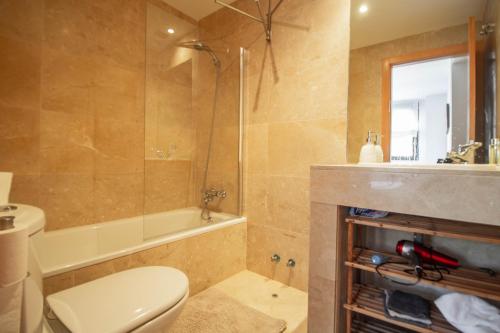 een badkamer met een toilet, een bad en een wastafel bij 3082 Res LOMAS DE CAMPOAMOR in Orihuela-Costa