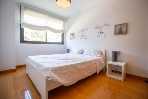 een witte slaapkamer met een bed en een raam bij 3082 Res LOMAS DE CAMPOAMOR in Orihuela-Costa