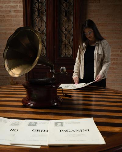 a woman reading a paper on a table with a mirror at LA PIANTA - Uma experiência na Villa de Monte Verde in Monte Verde