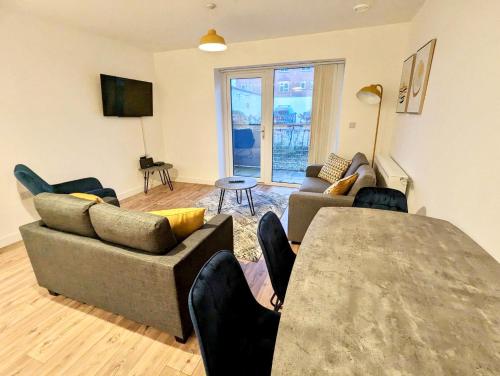 a living room with a couch and a table at Spacious 2 bed ground floor apartment, Free parking, close to Historic dockyard & Gunwharf Quays in Portsmouth