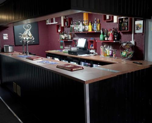 eine Bar in einem Restaurant mit einer Arbeitsplatte in der Unterkunft The Rollason Hotel in Birmingham