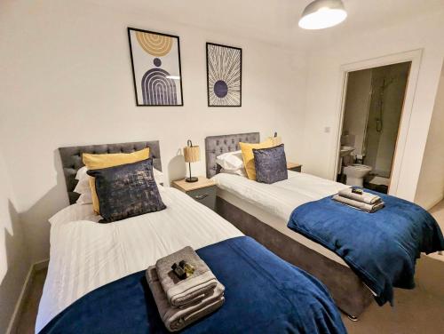 two beds in a bedroom with blue and white at Spacious 2 bed ground floor apartment, Free parking, close to Historic dockyard & Gunwharf Quays in Portsmouth