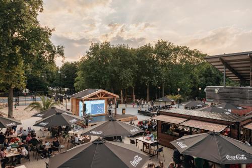 a group of people sitting at tables with umbrellas at KD 805 - Kijkduin in The Hague