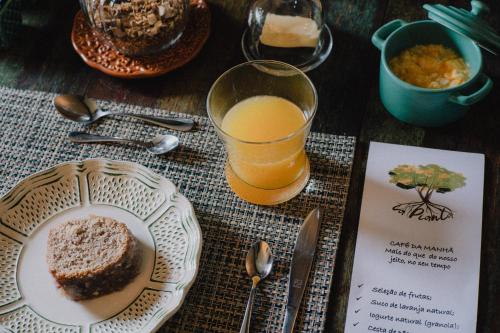 a table with a plate of bread and a glass of orange juice at LA PIANTA - Uma experiência na Villa de Monte Verde in Monte Verde