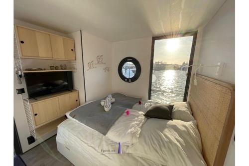a bedroom with a bed with a view of the water at Hausboot Fjord HAVEN mit Biosauna in Barth in Barth